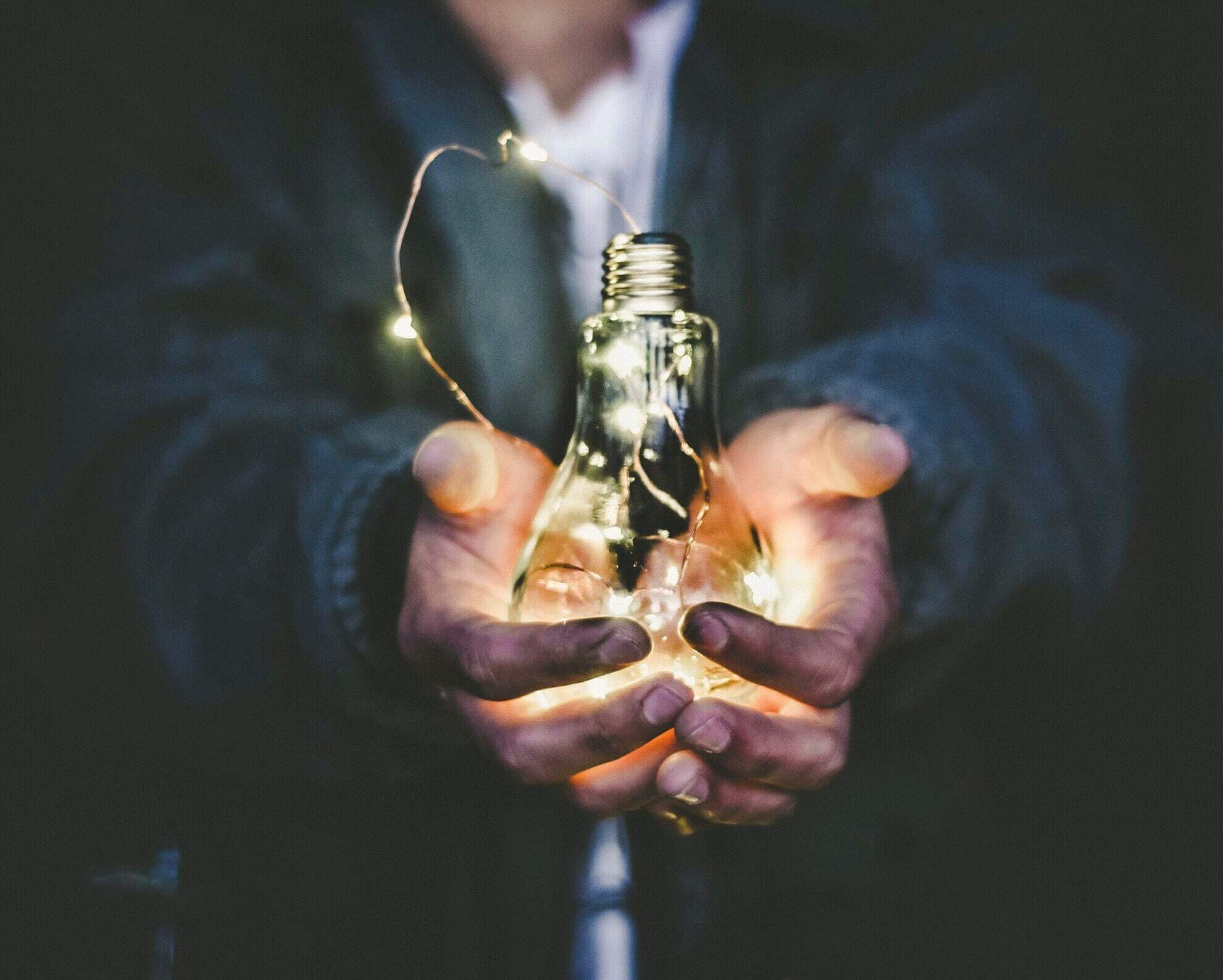 Hands holding a lightbulb