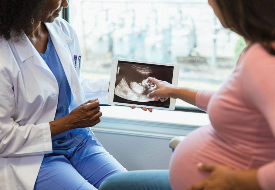 Doctor and pregnant woman reviewing an ultrasound image