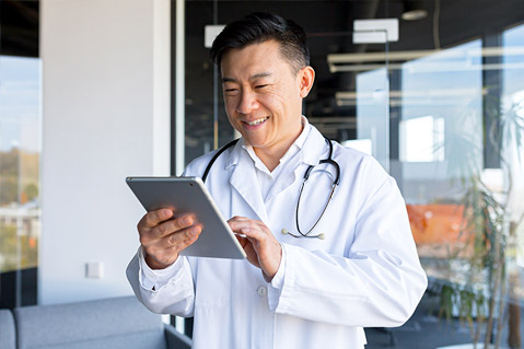Asian doctor looking at a tablet